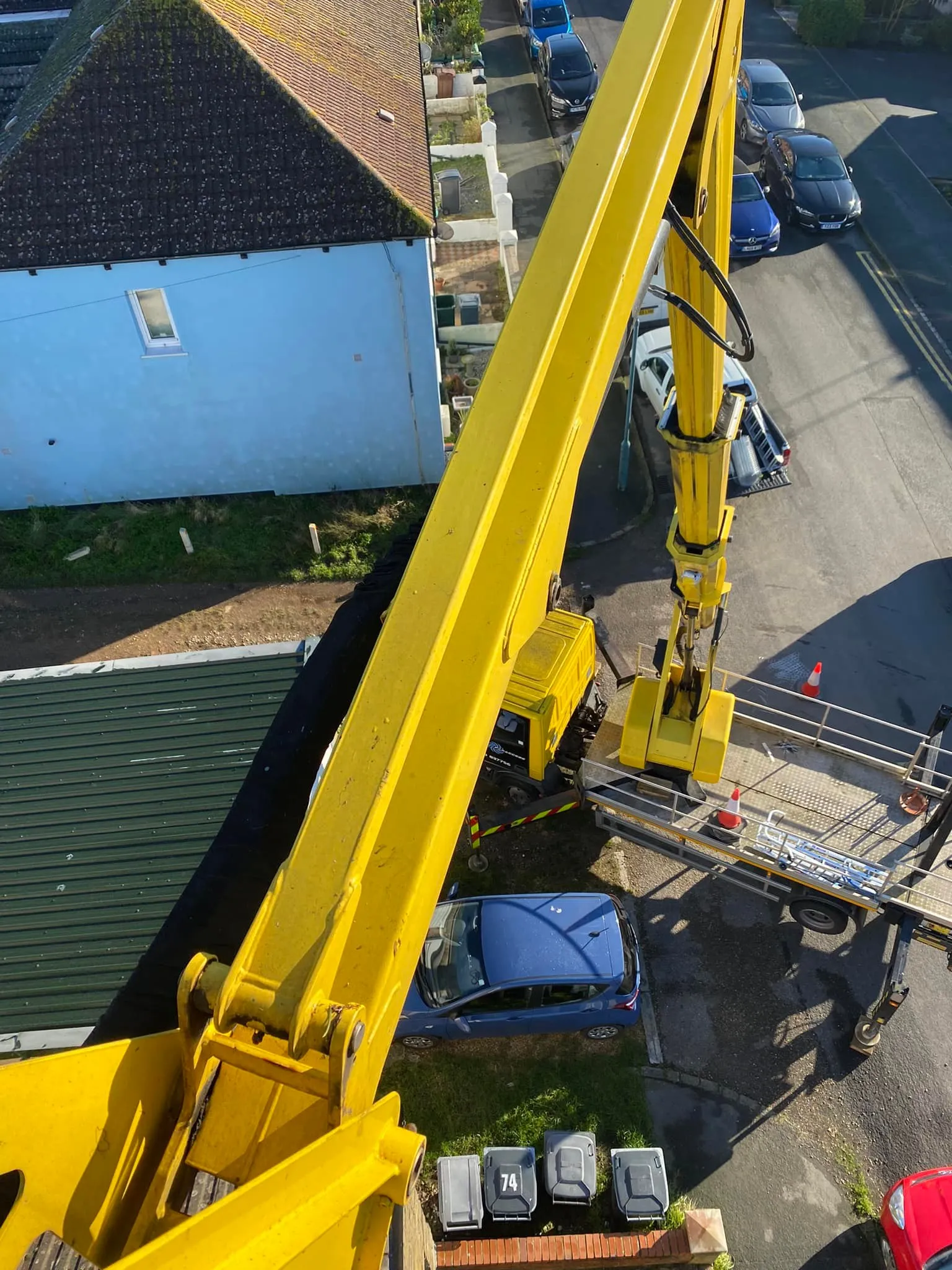 A yellow crane sitting on top of a building.