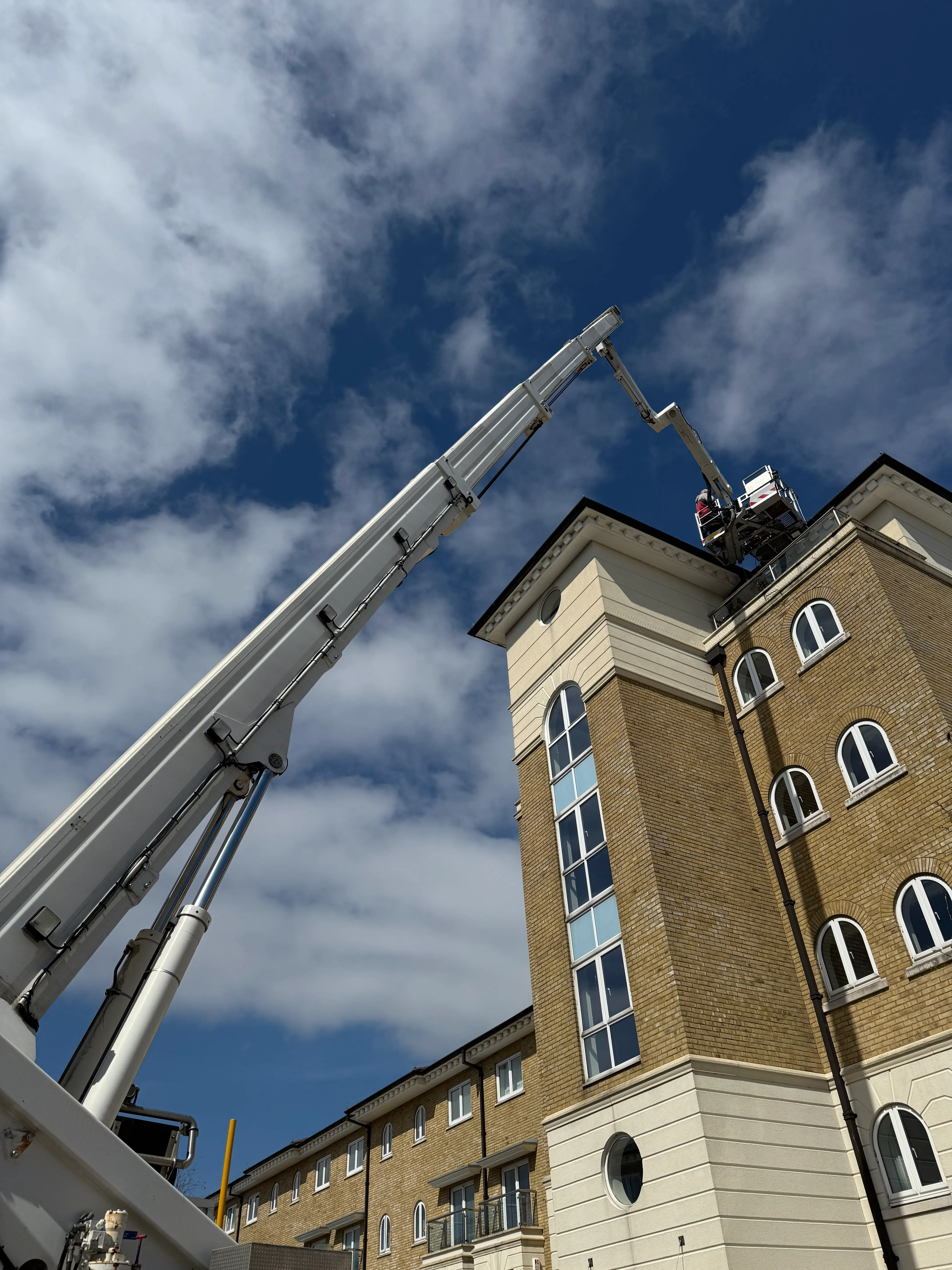 A man is working on the top of a tall building.